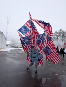 Man decked out with many US flags at Merrimack anti-ICE protest